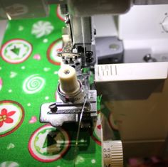 the sewing machine is working on the green fabric