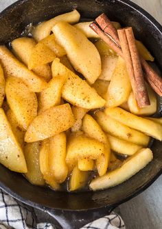 apples and cinnamon in a skillet on a table