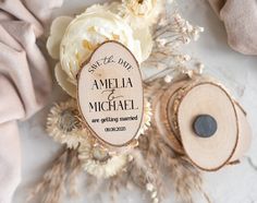 a wooden save the date sign on top of some wood slices and flowers next to it