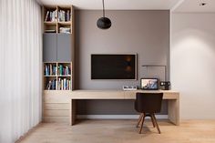 a room with a desk, bookshelf and television on the wall in it