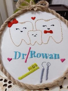 a close up of a embroidery on a piece of cloth with the words dr / rowan