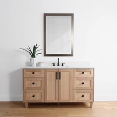 a bathroom vanity with two sinks and a large mirror on the wall above it, along with a potted plant