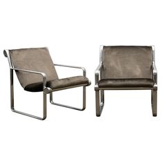 a pair of lounge chairs with armrests on each side, one in grey leather and the other in silver metal