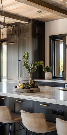 a kitchen island with stools and a potted plant on it in the center