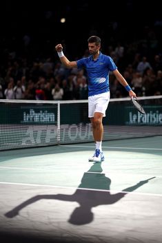 a male tennis player in action on the court with his racquet raised up