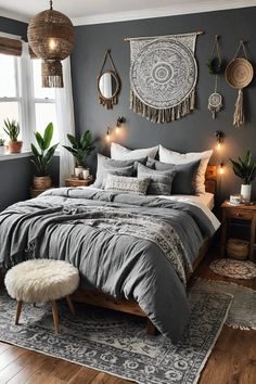 a bedroom with grey walls and wooden flooring is decorated with hanging plants, rugs, pillows, and blankets