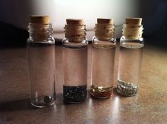 three glass bottles filled with different types of spices