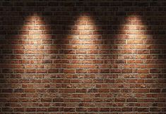 four spotlights on a brick wall in the dark