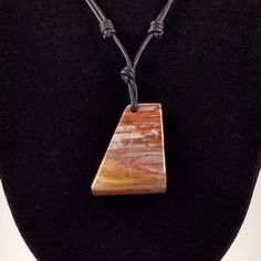 The Petrified Wood pendant is approximately 1.25 inches in length and 1 inch wide on natural black polished round leather. Both sides of the cabochon are polished. The necklace is adjustable from 16 inches to 32 inches by sliding the knots. The petrified wood in this cabochon is from Arizona from Araucarioxylon arizonicum trees. Petrified wood is fossilized remains of terrestrial vegetation. It is the result of a tree or tree-like plants having completely transitioned to stone by the process of Petrified Wood Jewelry, Kyanite Earrings, Sterling Silver Earrings Handmade, Stone Molds, Black Polish, Round Leather, Wood Jewelry, Wood Pendant, Organic Matter