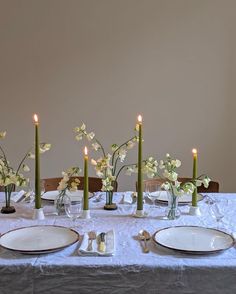 the table is set with candles and plates