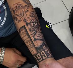 a man's arm with a lion and cross tattoo on the left side of his arm