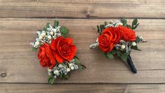 two red roses and baby's breath flowers are placed on a wooden surface together