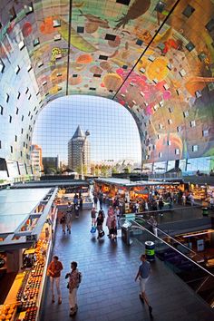 people are walking through an indoor market with many colorful tiles on the walls and ceiling