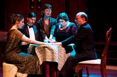 a group of people sitting around a table with a woman signing something on the table