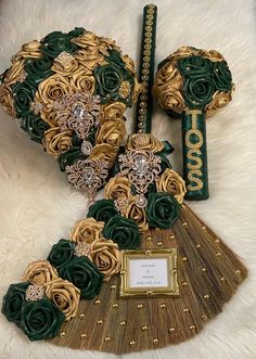 an elaborately decorated fan with gold and green flowers on it's side, sitting on a white furnishing