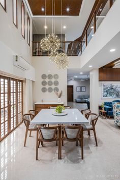 a dining room table with chairs and a chandelier hanging from it's ceiling