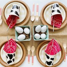 the table is set with plates, cups and utensils for an easter meal