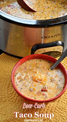 a bowl of soup sitting on top of a table next to a crock pot