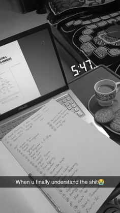 an open laptop computer sitting on top of a desk next to a cup of coffee