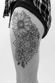 a woman's thigh with a sunflower tattoo on it