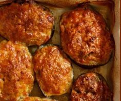 baked stuffed eggplant in a baking dish with tomato sauce on top and cheese on the side