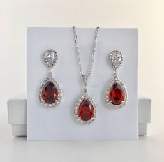 I've created this luxury red ruby cubic zirconia bridal tear drop earrings in rhodium plated brass setting. Earrings feature a large teardrop with pear cut red ruby cubic zirconia center surrounded by tiny round zirconia crystals. Teardrop dangles from a bright cubic zirconia ear stud. Total length of the earring is 3.5 cms. For matching necklace click: https://www.etsy.com/listing/469844682/red-ruby-cubic-zirconia-teardrop-bridal?ref=shop_home_active_26 For matching bracelet: https://www.etsy.c Red Cubic Zirconia Pear-shaped Jewelry, Red Pear-shaped Cubic Zirconia Jewelry, Red Pear-shaped Wedding Earrings, Red Pear-shaped Cubic Zirconia Earrings, Formal Red Cubic Zirconia Bridal Earrings, Ruby Teardrop Pendant Jewelry For Wedding, Wedding Ruby Teardrop Pendant Jewelry, Ruby Teardrop Pendant For Wedding, Ruby Red Wedding