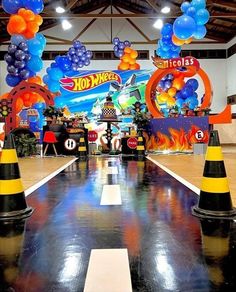 an indoor event with balloons and decorations on the walls, along with traffic cones in front of it