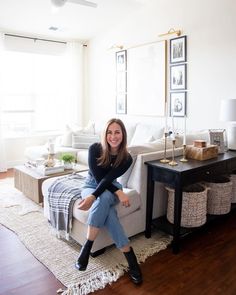 a woman sitting on top of a couch in a living room