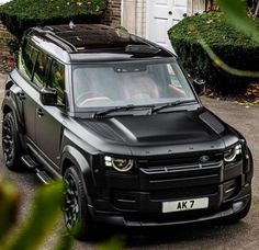 a black land rover parked in front of a house