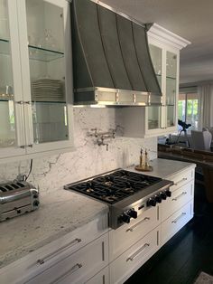 a stove top oven sitting inside of a kitchen next to a counter with glass shelves