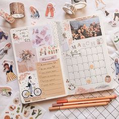 an open planner with stickers on it and some pencils laying next to it