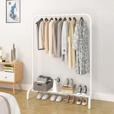 a white rack with shoes and clothes hanging on the wall next to a bed in a bedroom