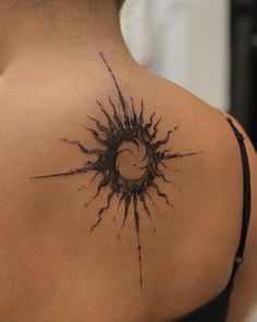 the back of a woman's shoulder with a sun and moon tattoo on it