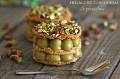 three desserts are stacked on top of each other with nuts and pistachios