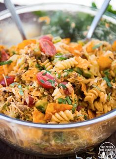 a bowl filled with pasta and vegetables on top of a table