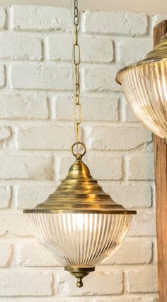 two light fixtures hanging from a brick wall