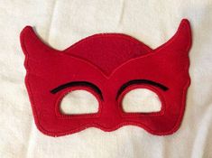 a red mask with black eyes on a white sheet