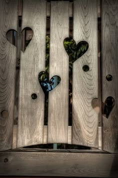 a wooden fence with hearts cut out of it and a quote written on the side