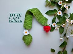 a crocheted piece of fruit sitting on top of a table next to flowers