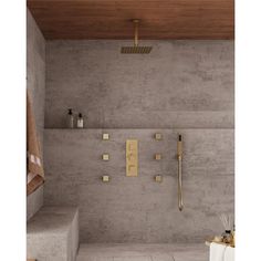 a bathroom with concrete walls and tile flooring, including a gold shower faucet