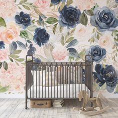 a baby crib in front of a floral wallpaper