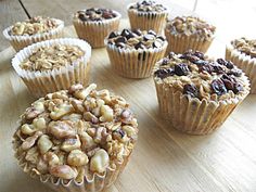 several muffins with nuts and raisins in them on a wooden table