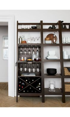 a wooden shelf filled with lots of wine glasses and other items on top of it