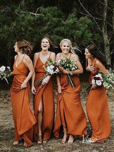 a group of women standing next to each other in front of some trees and bushes