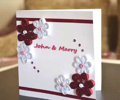 a white card with red and white flowers on it