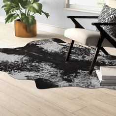 a black and white area rug in a living room with a plant on the floor