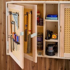 a wooden cabinet with tools and pegs in it