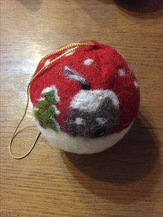 a red and white ornament sitting on top of a wooden table