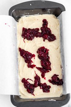 a pan filled with white frosting and cranberries on top of a table