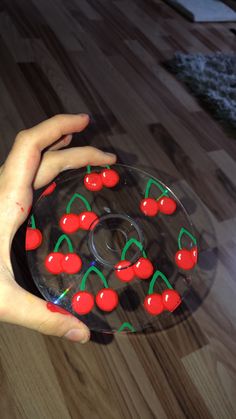 a person holding a plate with cherries on it